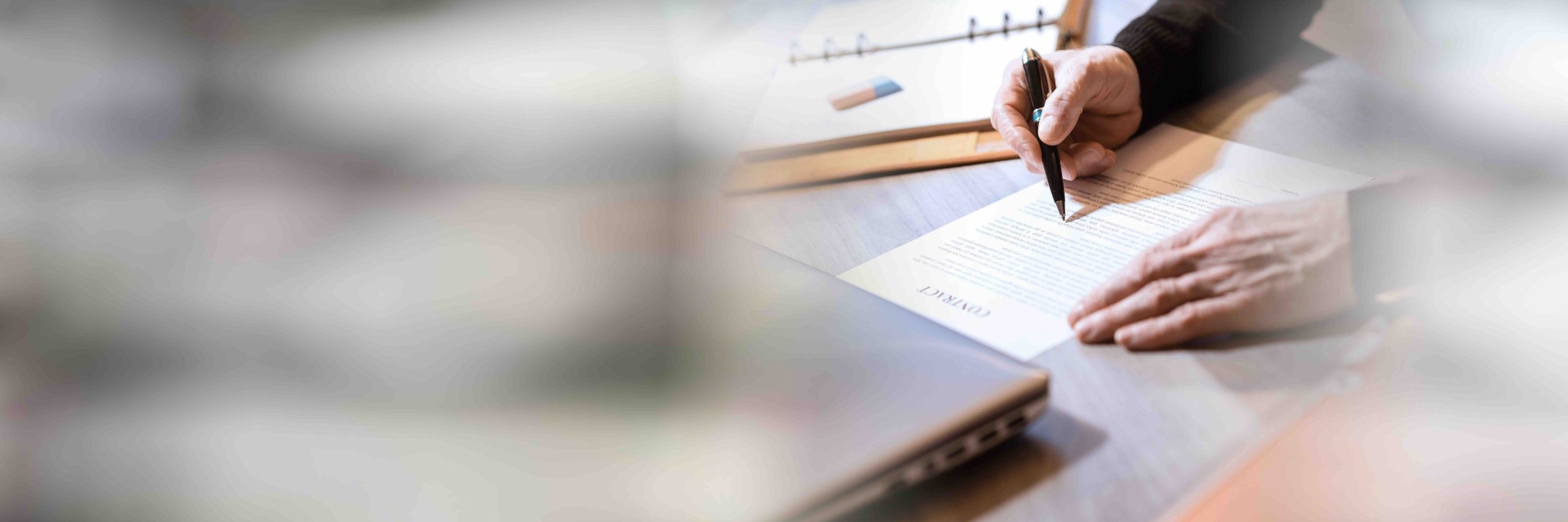 Senior businessman reviewing terms of contract; panoramic banner Legal contract with a mans hand - The Process of Buying a House